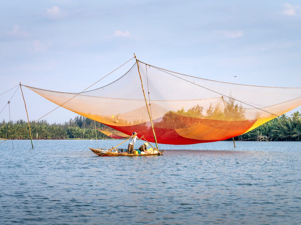 Fishermen floating in boat under large net on Thu Bon River, Hoi An tour